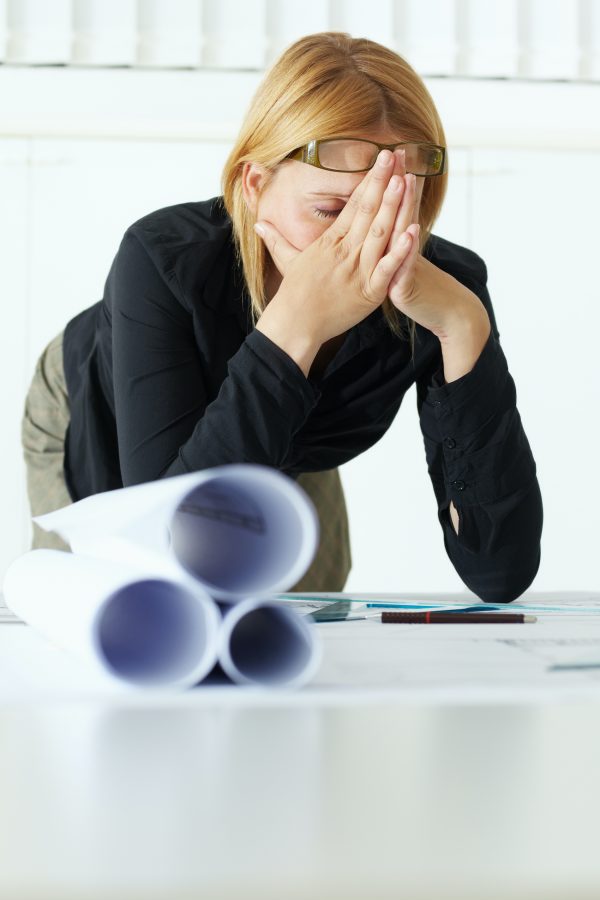 business woman holding her head due to a headache