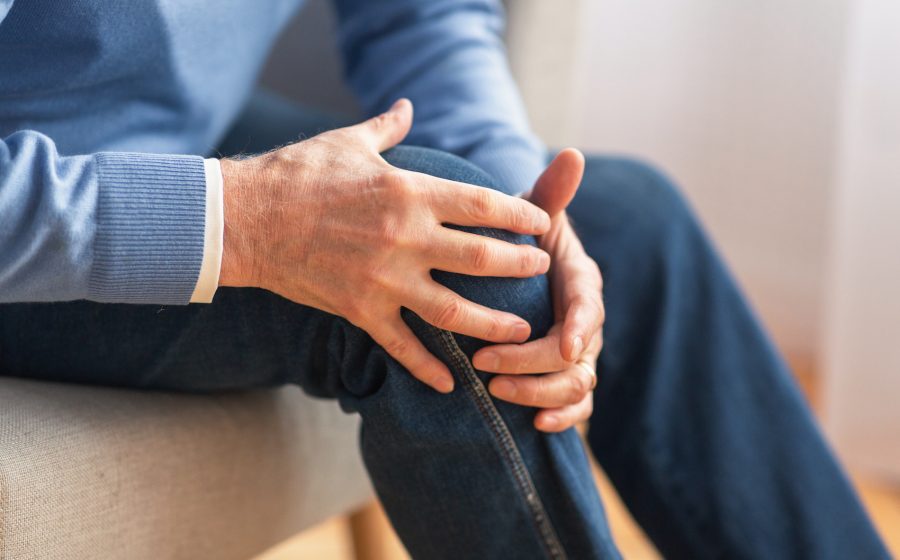 senior man holding his knee due to pain